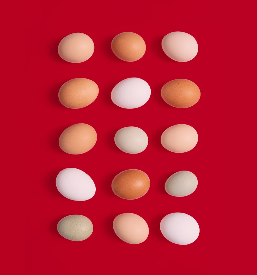 different colored eggs on red background