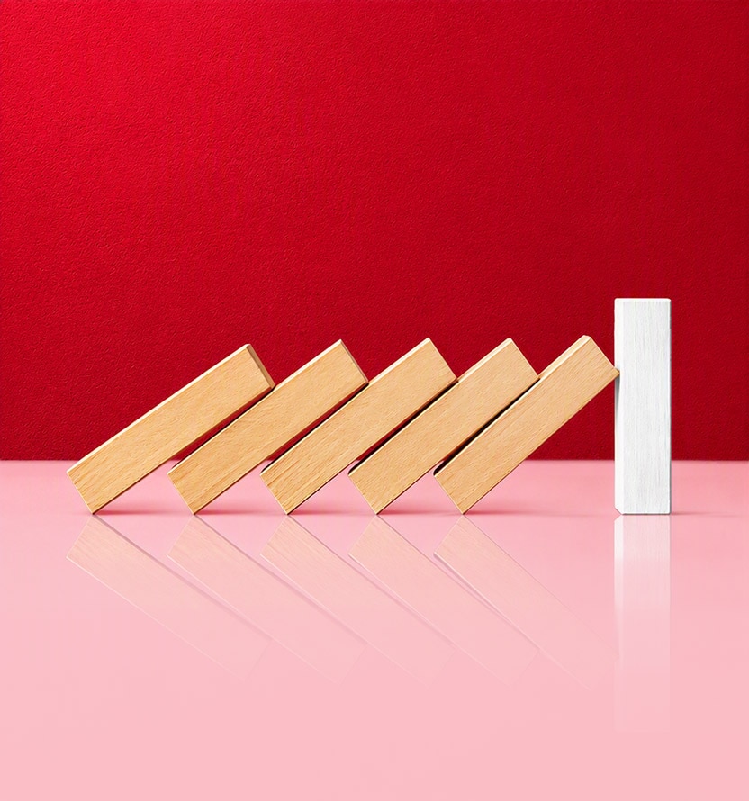 A row of wooden blocks leaning like falling dominoes against a single upright white block on a red background.