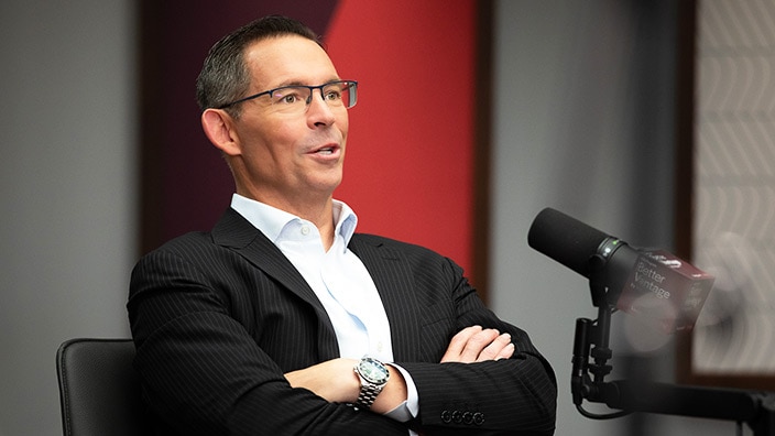 Photo of Joe Davis seated, speaking into a microphone on the Better Vantage podcast