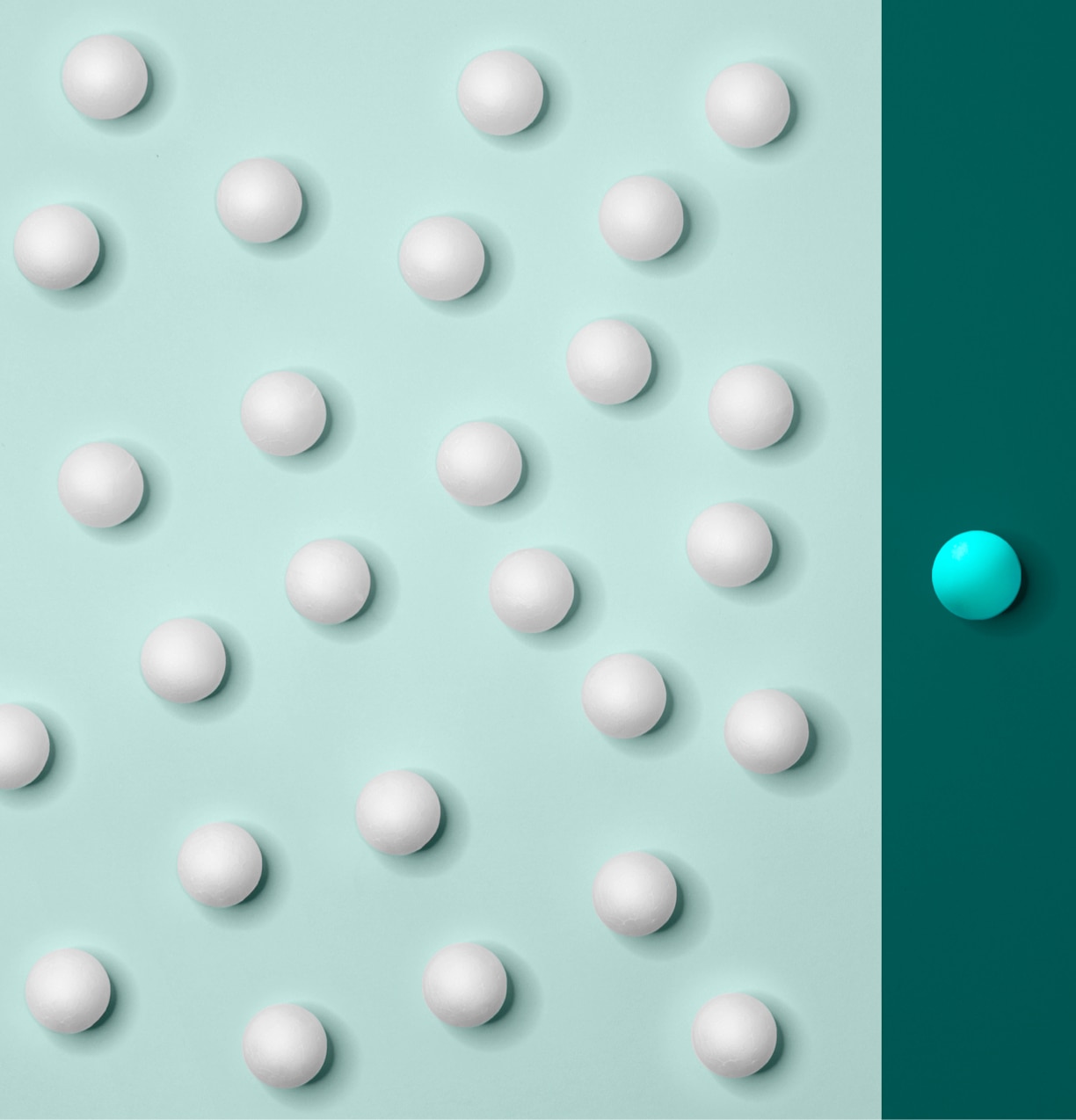 Illustration showing several balls on a light blue background and one other ball by itself on a dark blue background. 