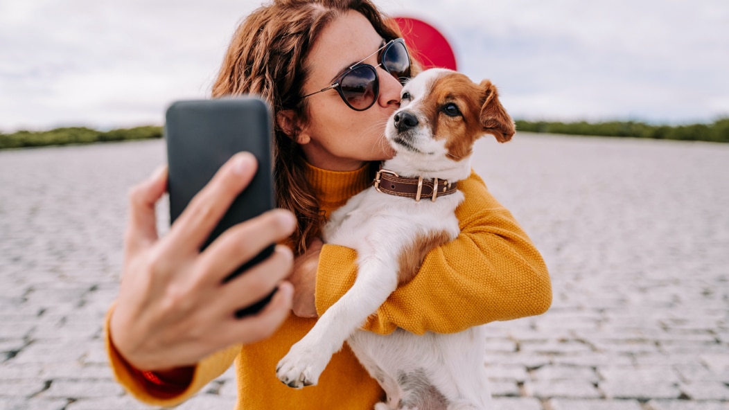 A person taking a selfie with a dog.