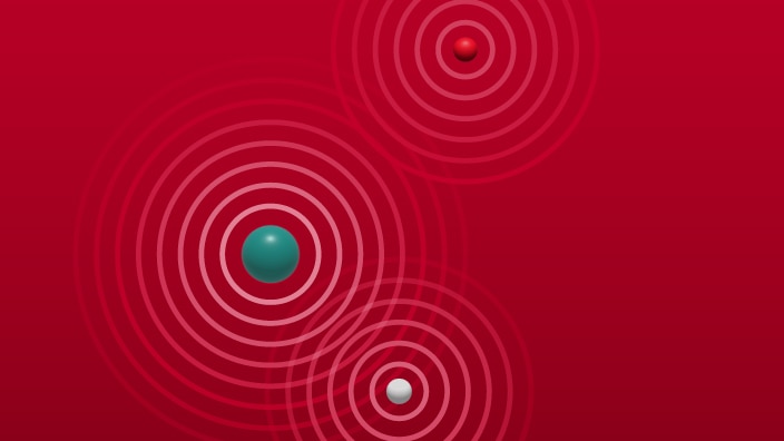 Abstract illustration of three spherical objects on a red background, each surrounded by concentric circular wave patterns. One large teal sphere appears on the left side, a smaller red sphere is positioned in the upper right, and a small white sphere is located toward the lower right. The circular rings around each sphere overlap slightly, suggesting signals, ripples, or radiation emitting outward in all directions. The background is a uniform gradient of red, and no text is present.