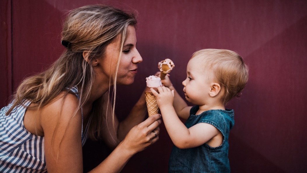 A woman and child sharing ice cream together. 