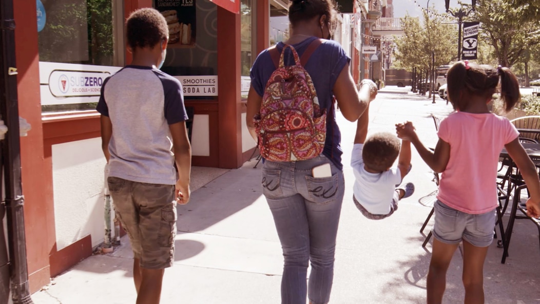 School age children of different ages walking down the street. Vanguard supports many children like this through our Strong Start for Kids and other volunteer programs.